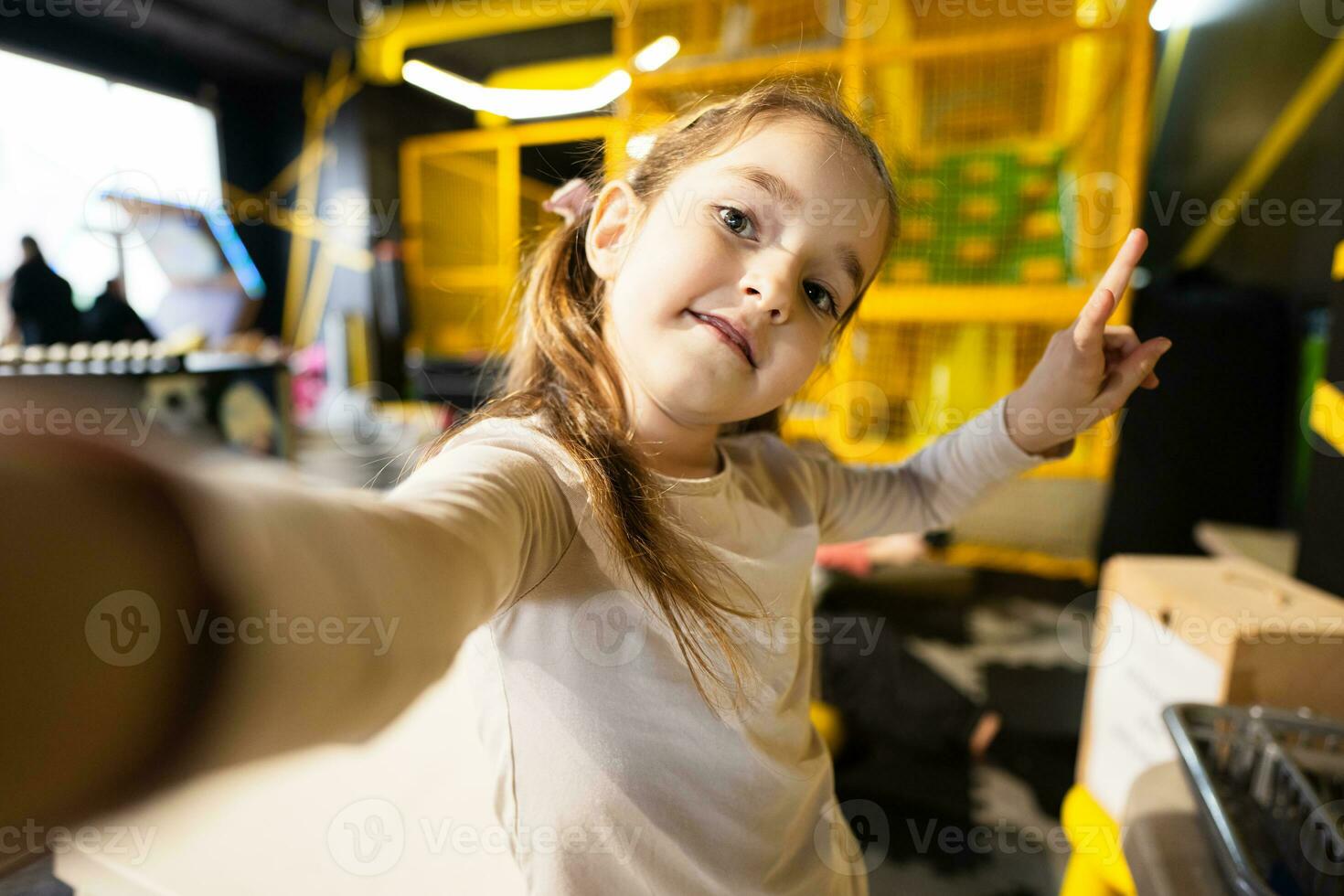 pré-escolar menina fazer selfie às crianças jogar Centro. foto