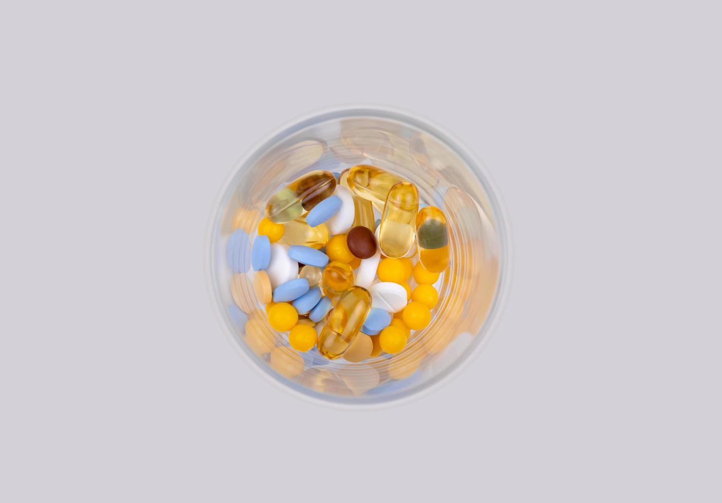 dose dos comprimidos coloridos no copo foto