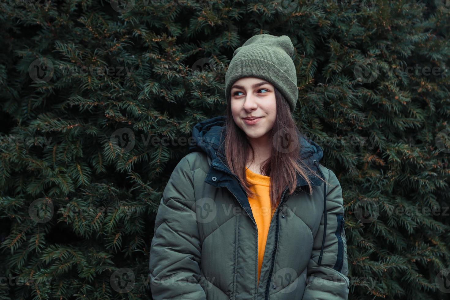 retrato de uma linda garota sorridente perto de uma árvore de Natal ao ar livre foto