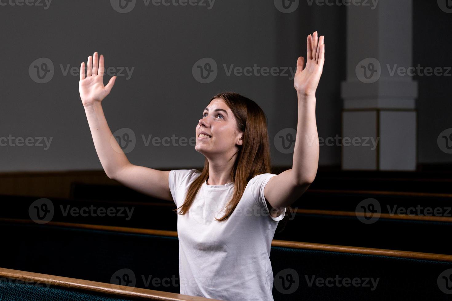 uma menina cristã orando com o coração humilde na igreja foto