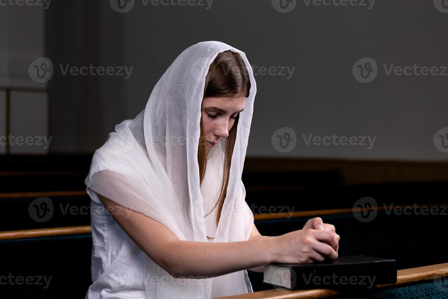 uma menina cristã orando com o coração humilde na igreja foto