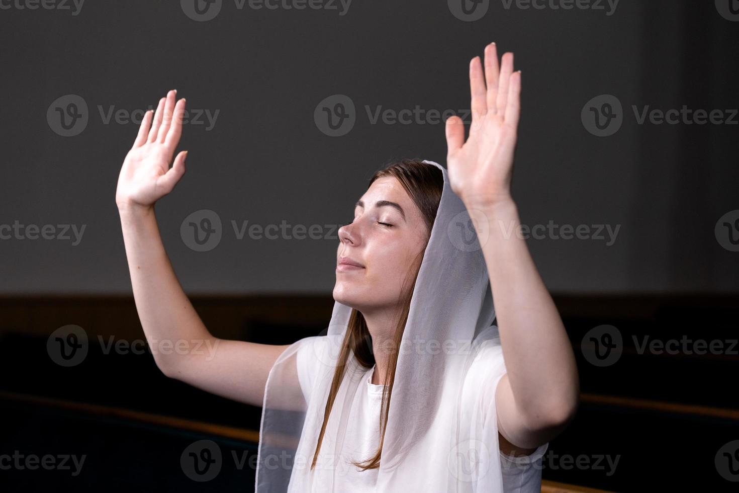 uma menina cristã orando com o coração humilde na igreja foto