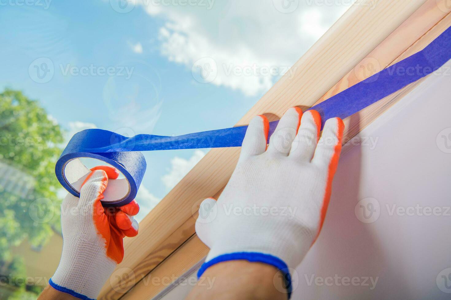 masculino construção trabalhador aplicando do pintor fita para uma parede antes pintura foto