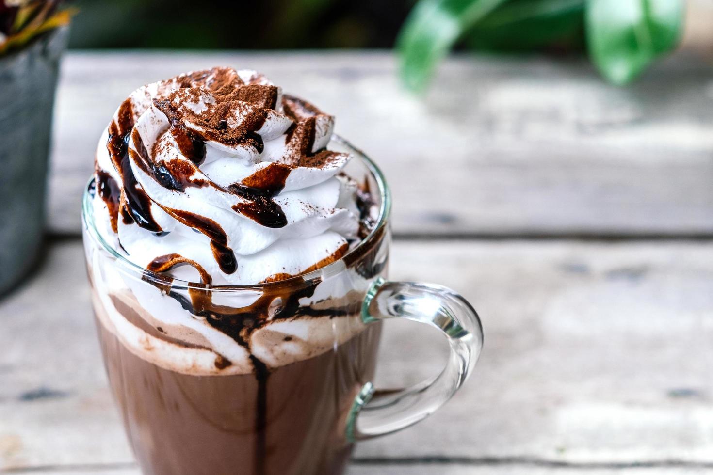 cacau de chocolate quente em caneca de vidro com chantilly foto