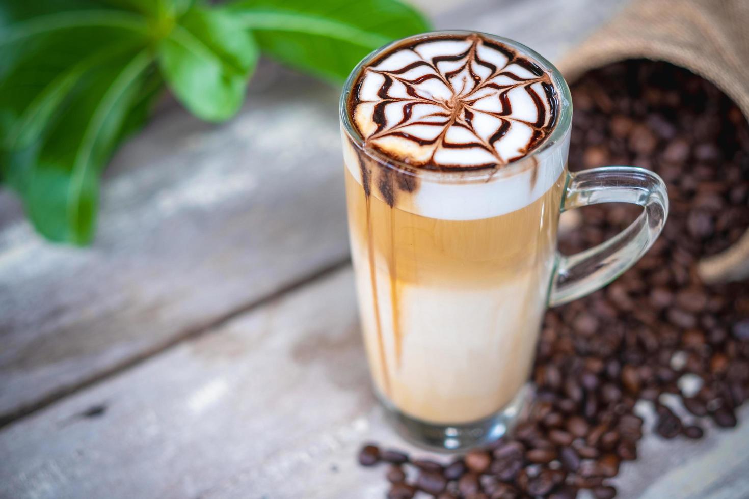 café com leite quente macchiato com calda de chocolate art foto