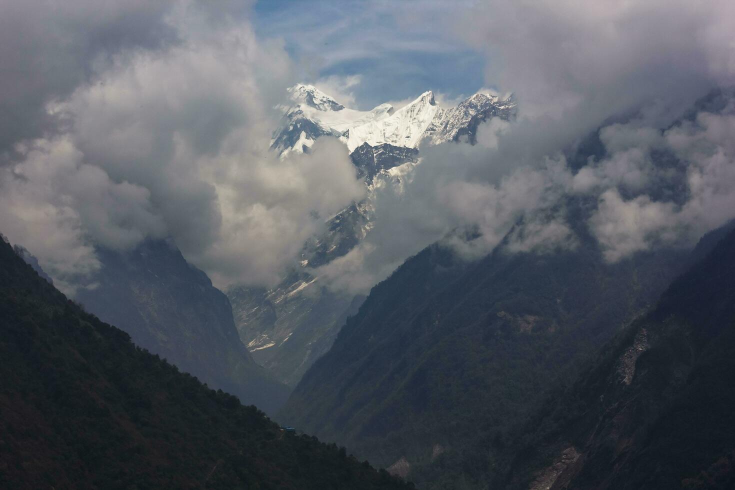 uma lindo panorama do nuvens cobertura a flancos do a sul Annapurna alcance visto a partir de a Vila do chomong em a Annapurna base acampamento trilha dentro a Nepal himalaya. foto