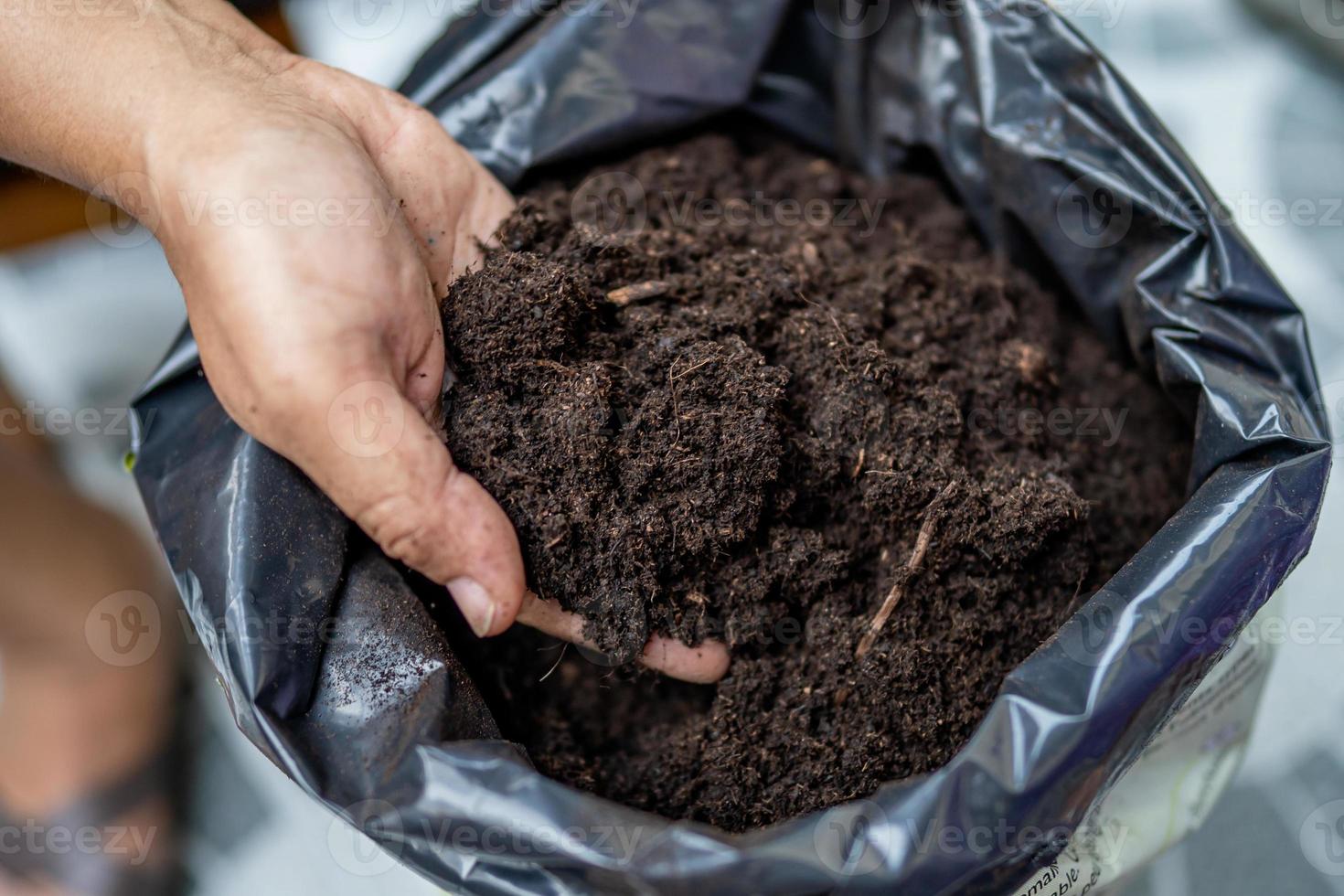 mulher asiática segurando turfa, musgo, matéria orgânica, melhora o solo para cultivo de plantas hortícolas foto