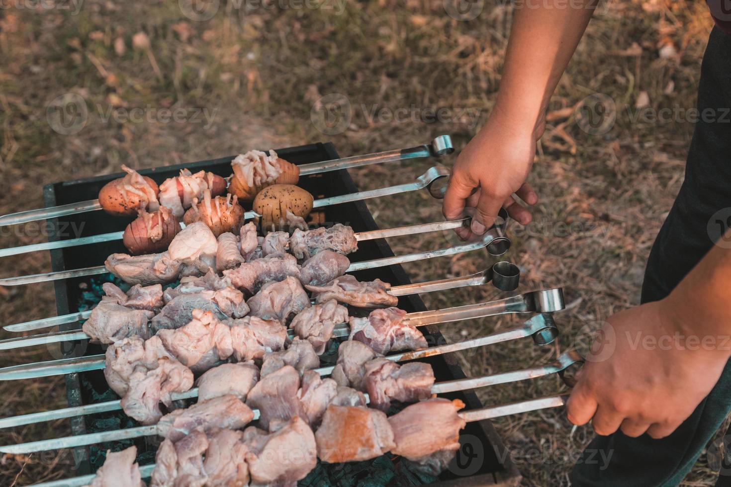 homem fritando shish kebab na grelha foto