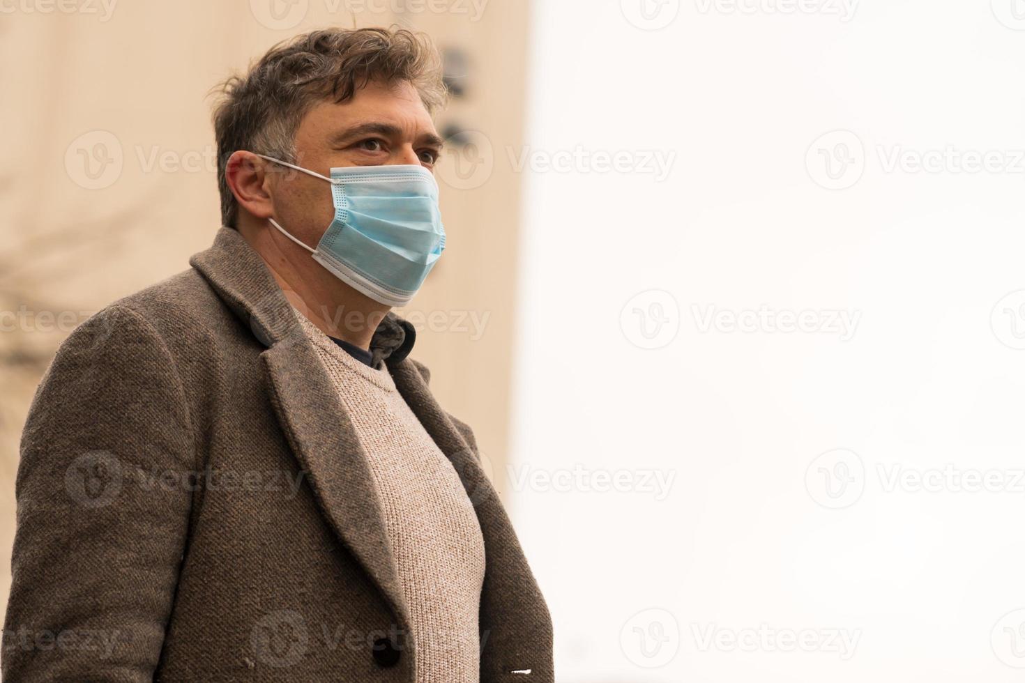 surto de doença coronavírus pandemia retrato de um homem cobrindo o rosto com uma máscara médica para proteger o nariz e a boca foto