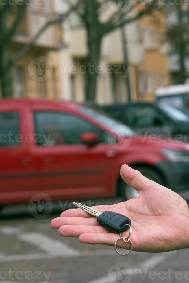 mão masculina segurando a chave de um carro foto