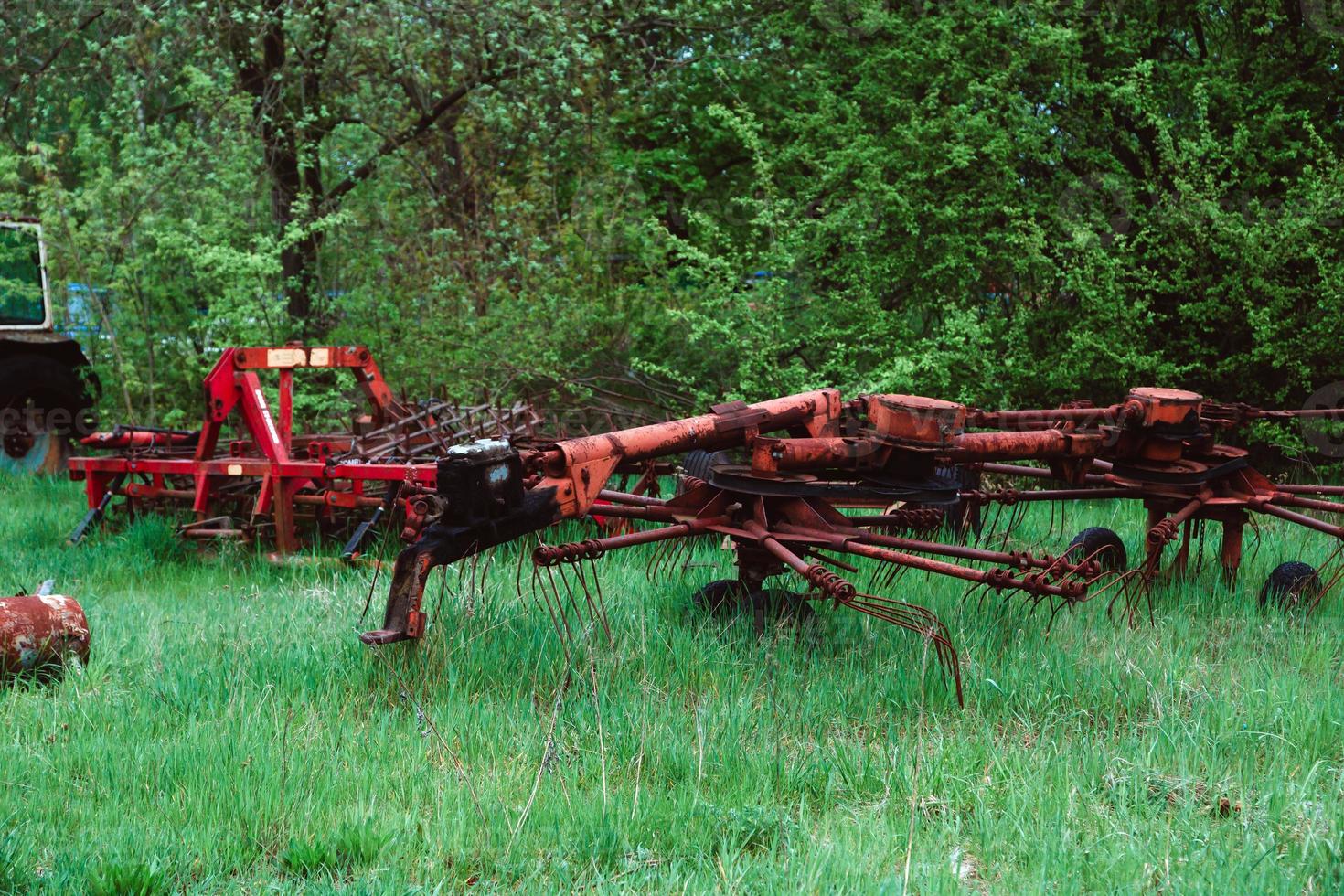 tratores antigos e outros materiais agrícolas em um ferro-velho foto