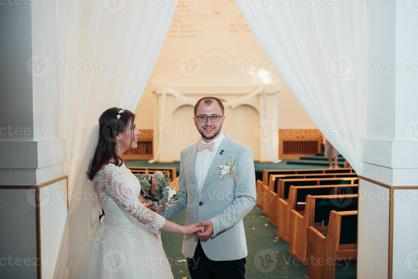 jovem noiva e noivo no dia do casamento em uma igreja foto