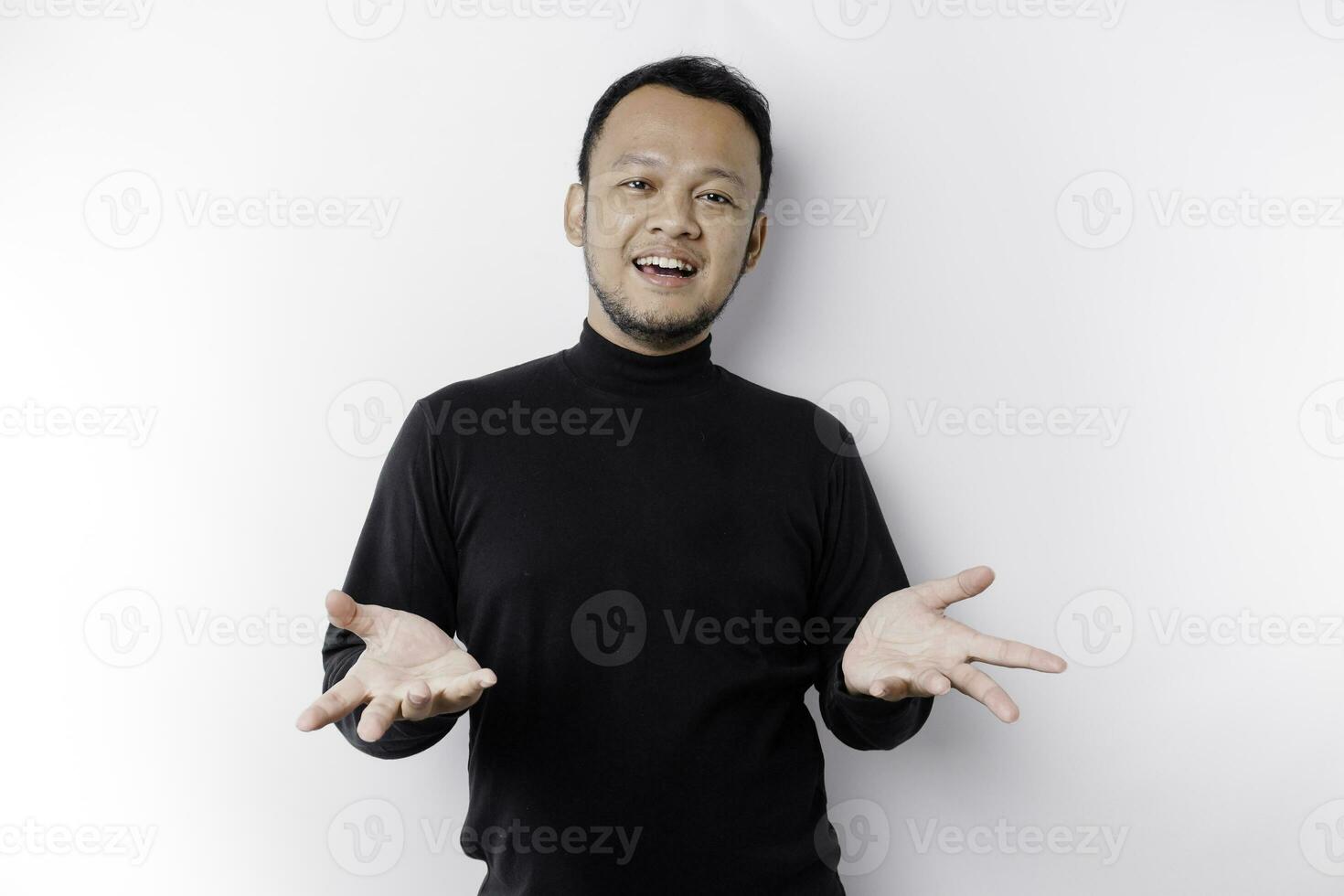 jovem ásia homem vestindo Preto camiseta apresentando a idéia enquanto olhando sorridente em isolado branco fundo foto