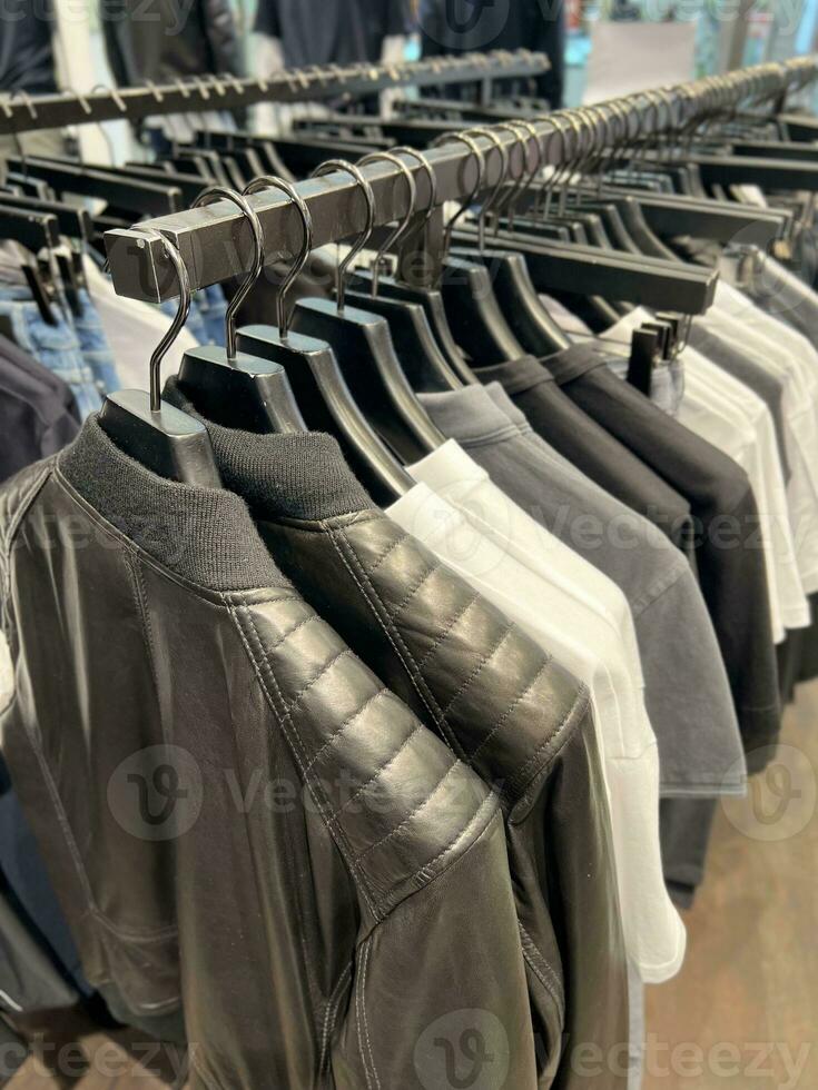 roupas em uma cabide dentro uma loja para homens foto