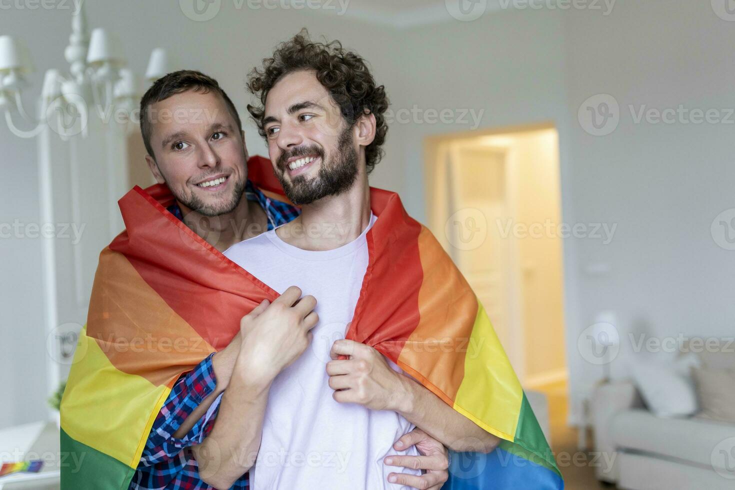 afetuoso masculino gay casal dentro de casa. homem abraçando dele namorado a partir de atrás às lar. gay casal a comemorar orgulho mês foto