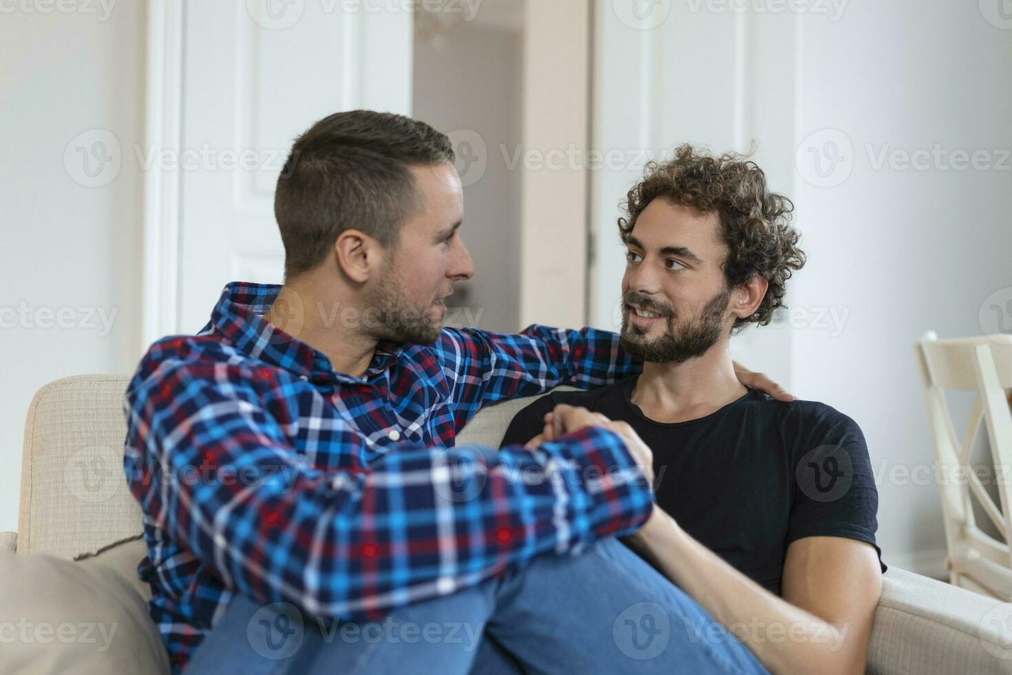 alegre jovem gay casal sentado junto. dois afetuoso masculino amantes sorridente alegremente enquanto abraçando cada outro. jovem gay cupê ser romântico. foto