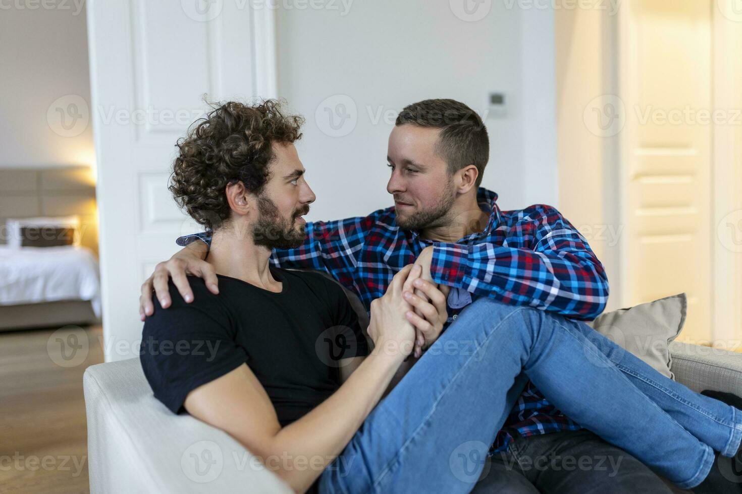 bonito gay casal deitado dentro cama junto. romântico jovem gay casal abraçando cada de outros carinhosamente. dois alegre jovem masculino amantes vínculo com carinho às lar. foto