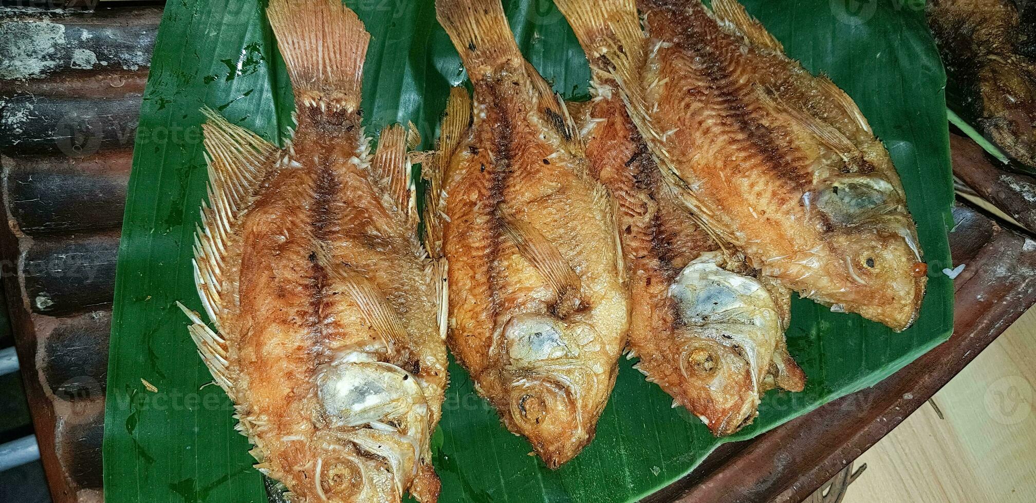 frutos do mar prato servido em a mesa e prato a partir de acima com diferente tipo do prato a partir de frito peixe barracuda, pargo, atum mandíbulas, e Além disso misturar do tropical legumes foto