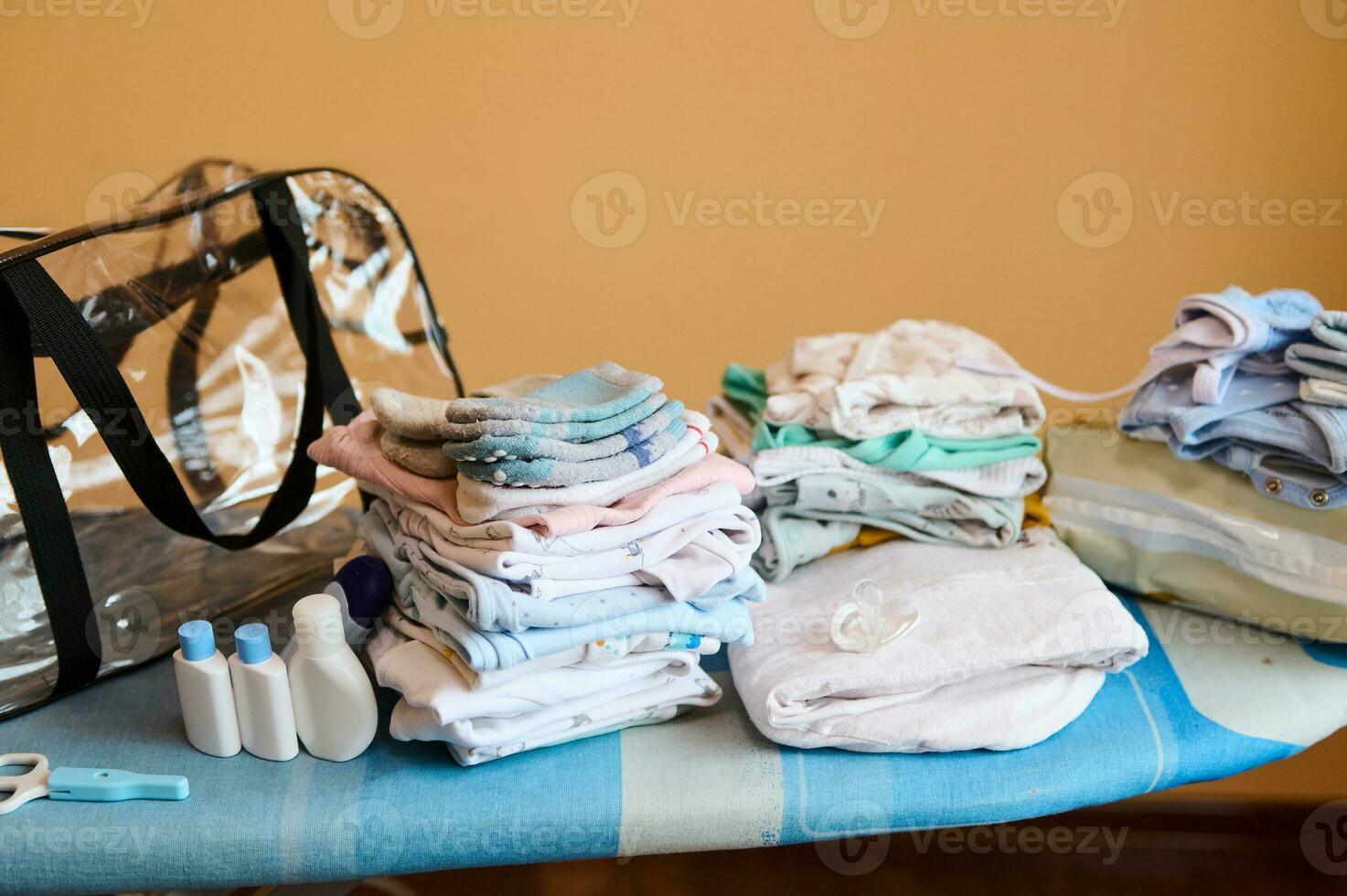 esvaziar saco perto uma pilha do passado a ferro bebê roupas, orgânico cosméticos em passar roupa quadro, preparado para maternidade hospital foto