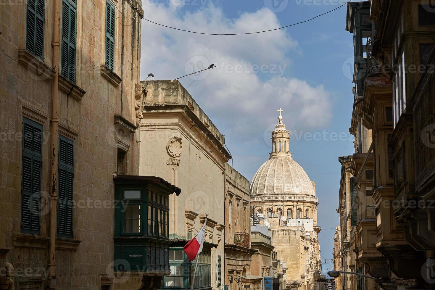 rua estreita tradicional e igreja em valletta, malta foto