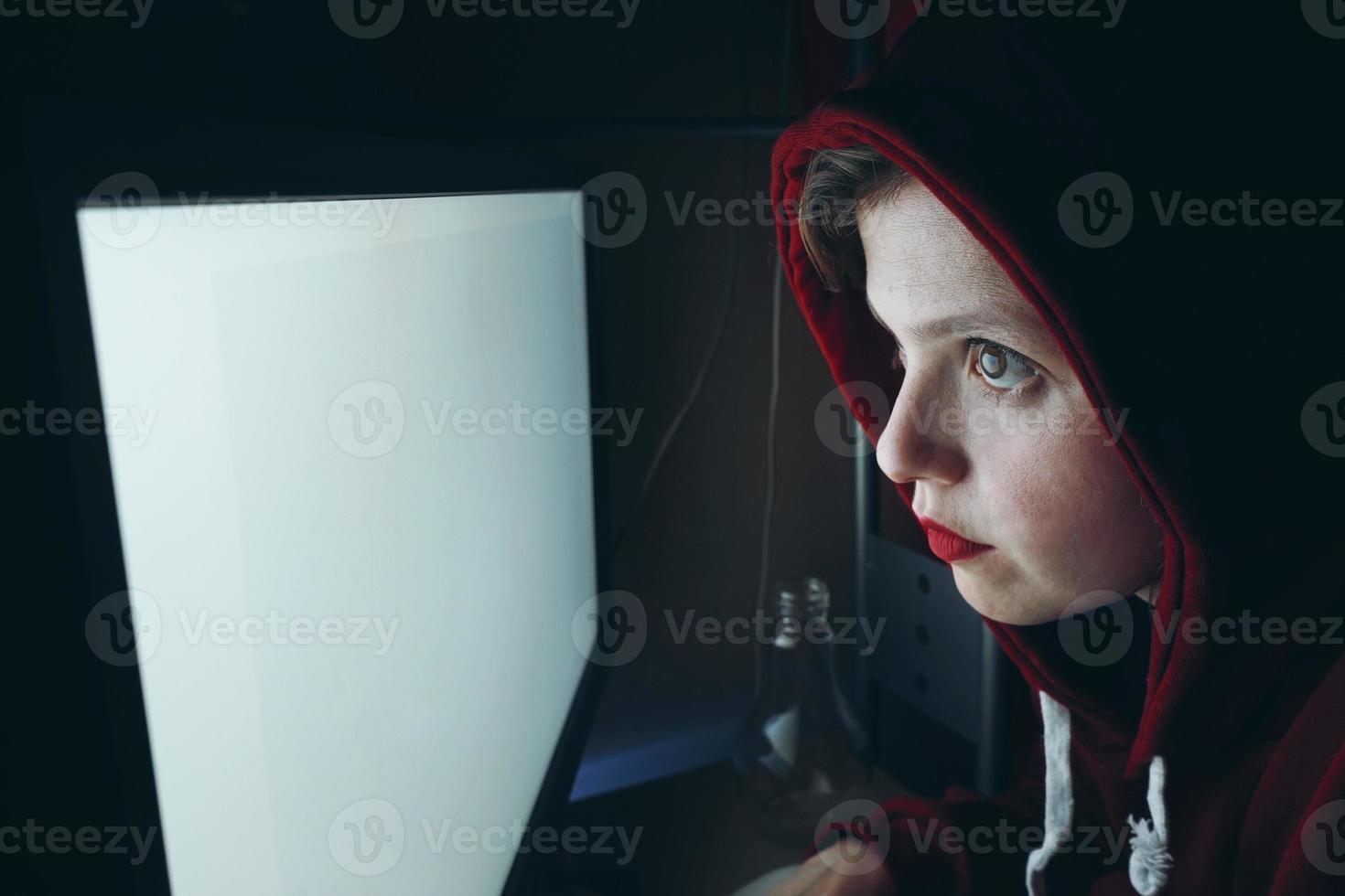 jovem hacker em frente a uma tela de pc branca foto