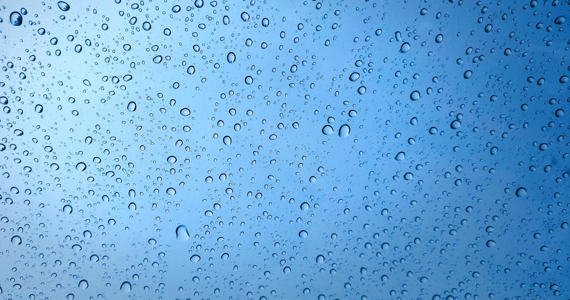 gotas de chuva no fundo da janela de vidro azul foto