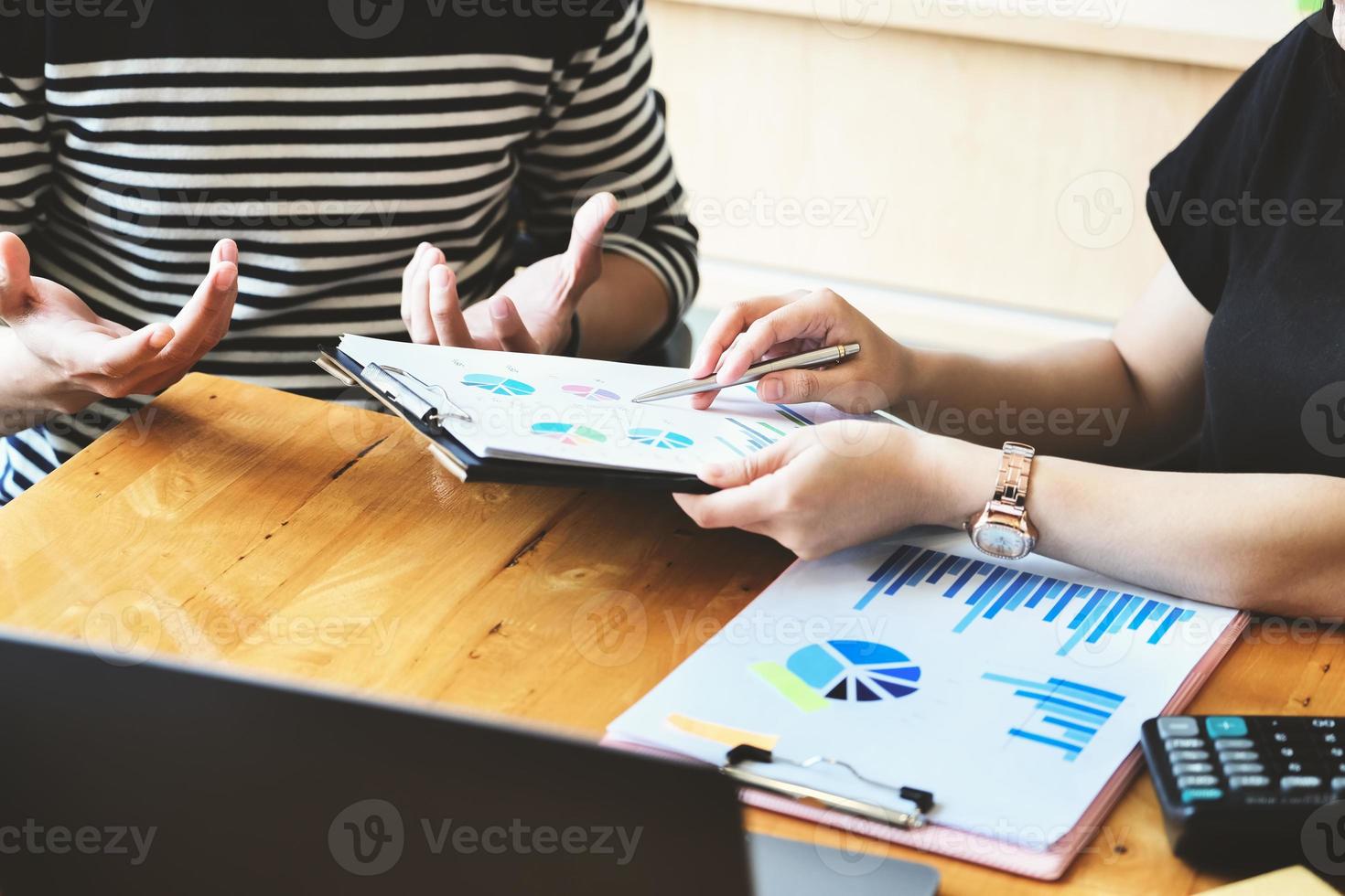 concentre a mão segurando a caneta, ponto no documento gráfico com a mulher de negócios e discussão de parceria e troca de ideias durante o trabalho foto