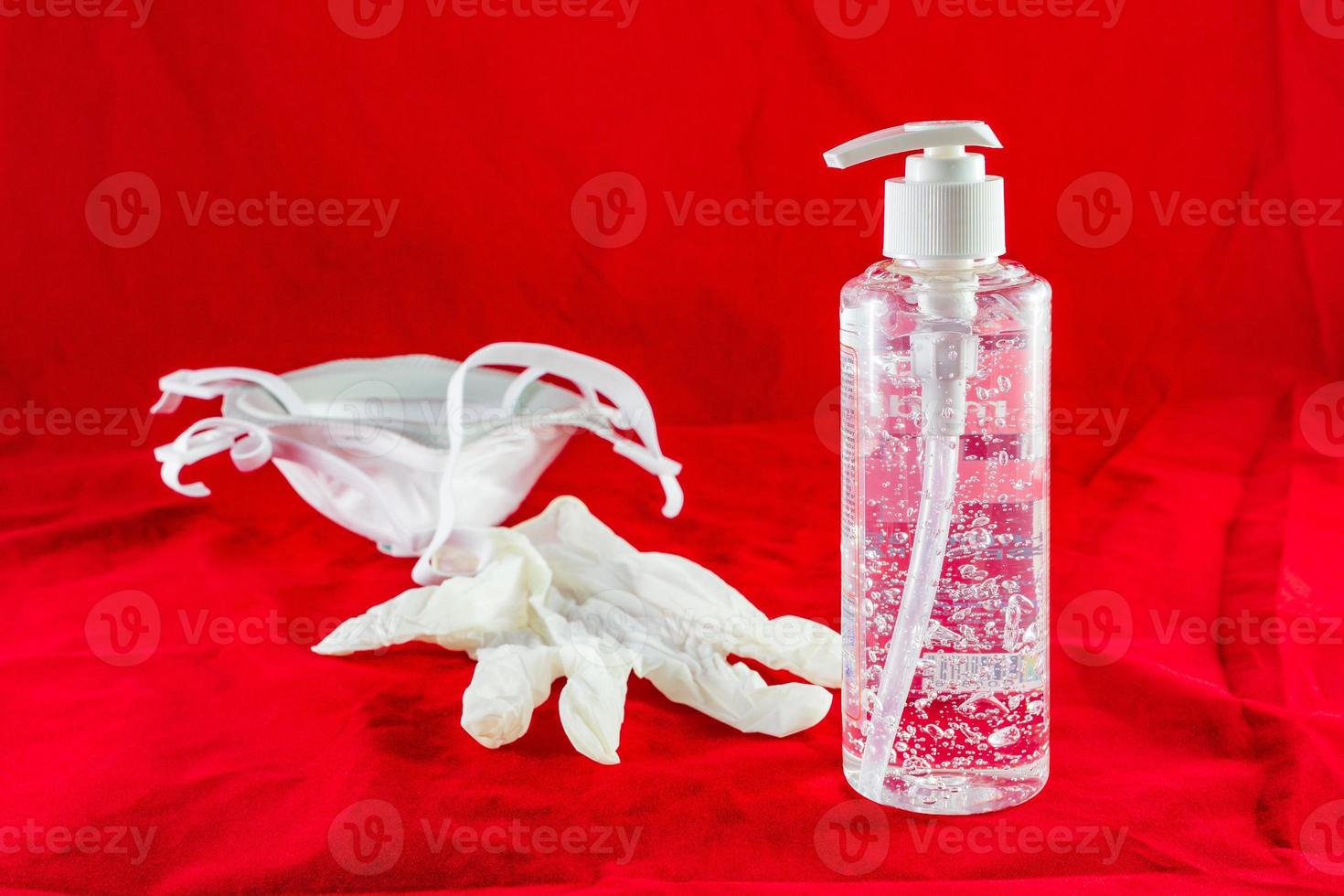 luvas de látex brancas de gel higienizante e máscara no conceito de proteção vermelha contra o vírus da poluição da gripe e do coronavírus foto
