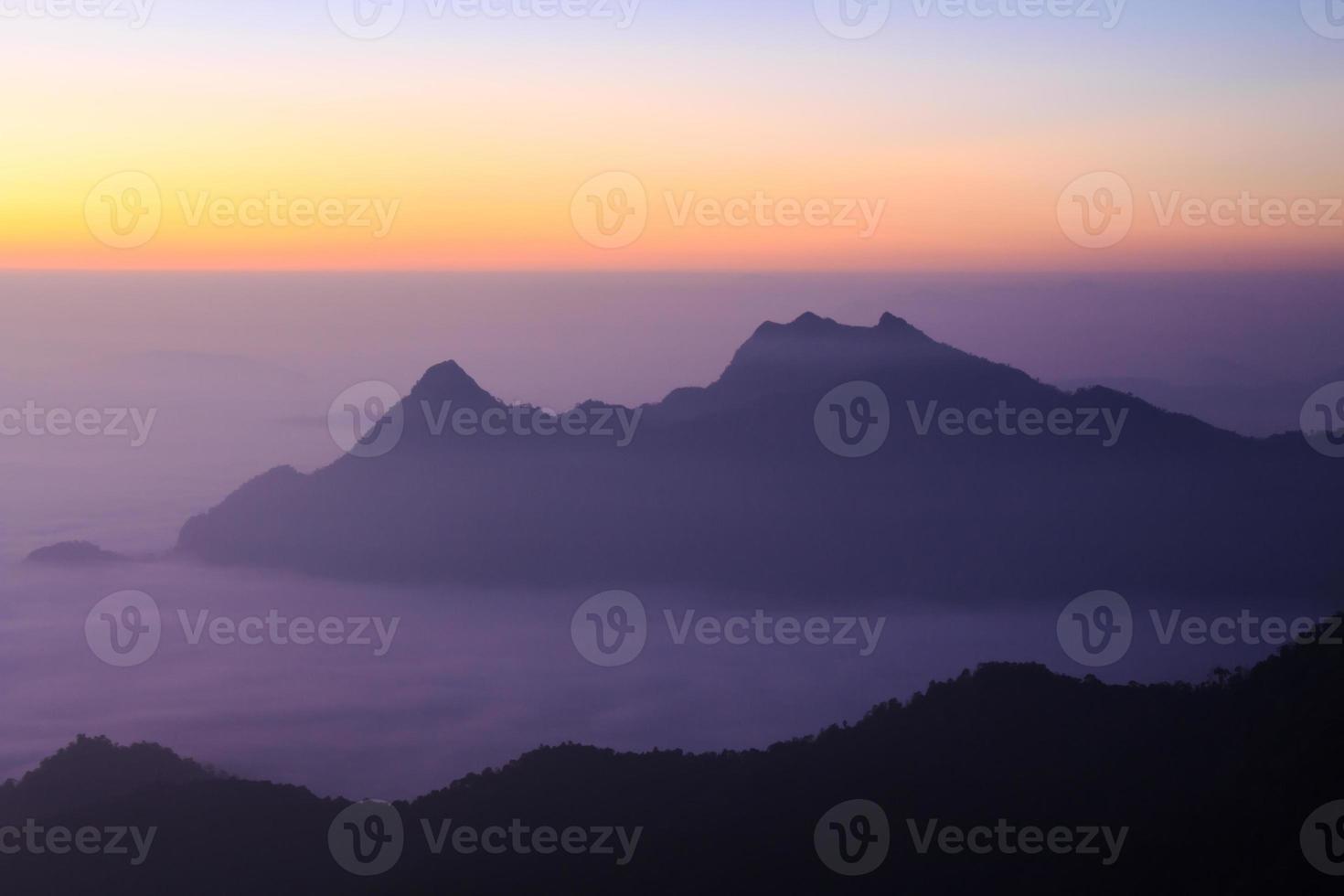 mar de névoa e silhueta da montanha com nascer do sol pela manhã em phu chi fa chiangrai tailândia foto