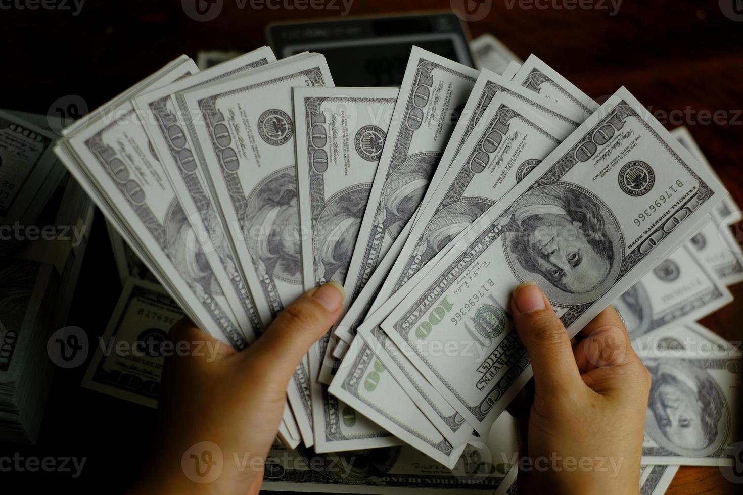 mãos segurando notas de dinheiro 100 usd foto