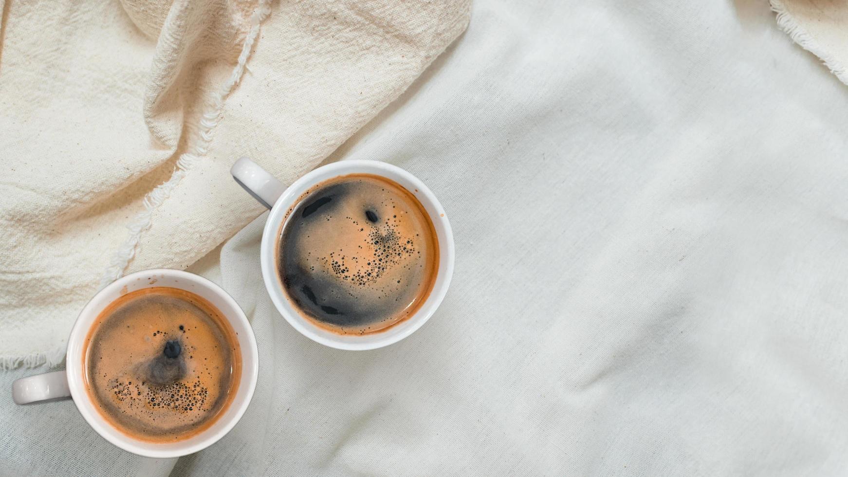 vista superior de uma xícara de café em uma toalha de mesa branca foto