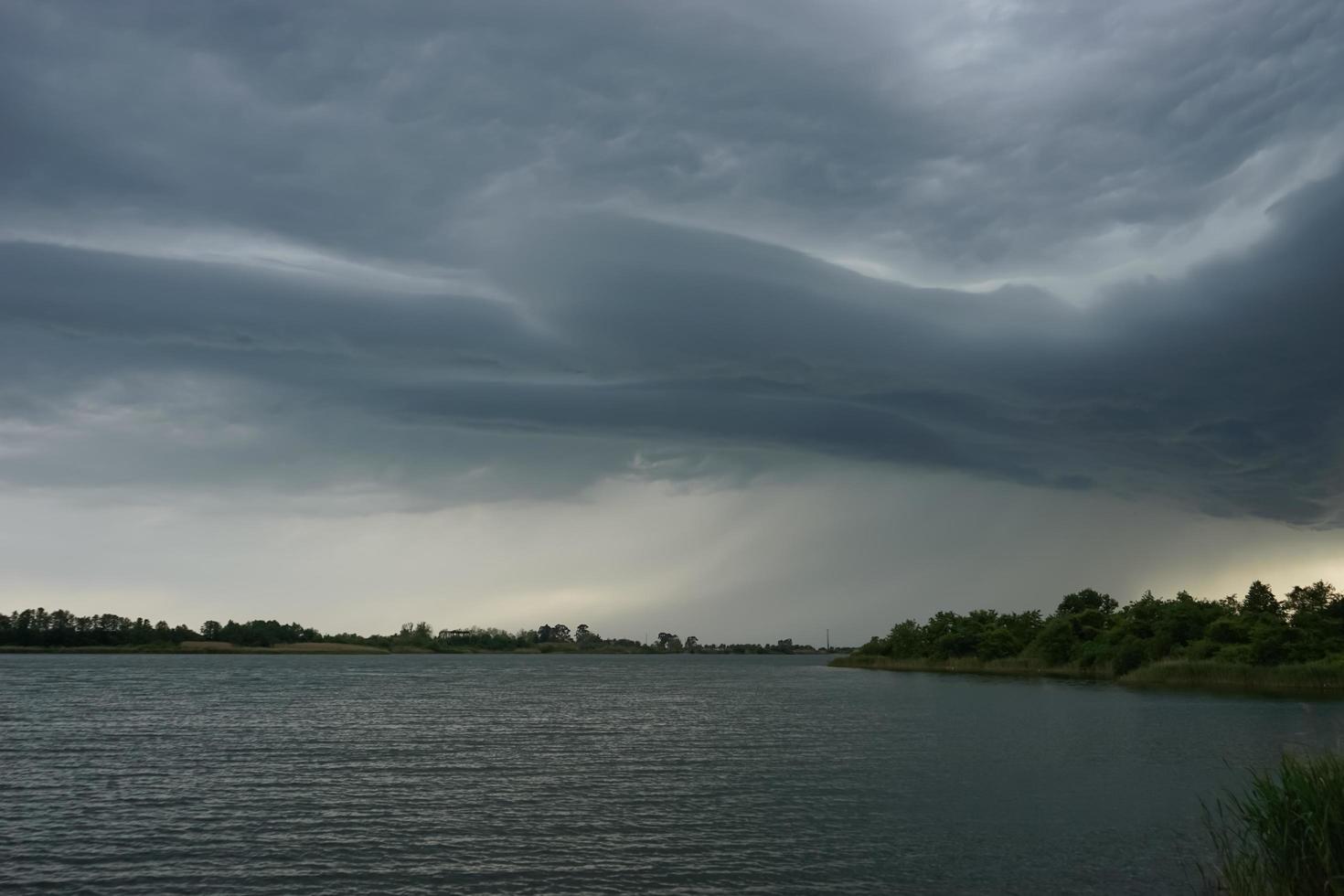 paisagem dramática com nuvens de tempestade sobre o lago foto