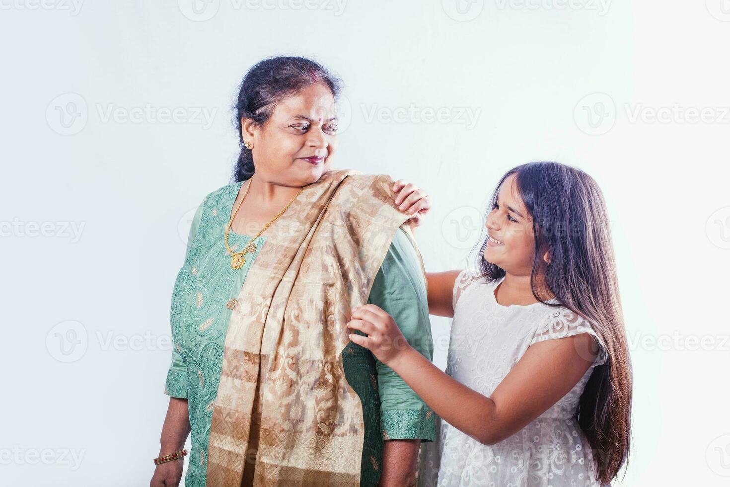 fofa indiano pequeno menina ajudando dela avó vestem uma dupatta foto