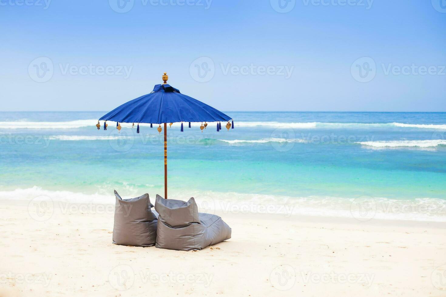 guarda-chuva com feijão bolsas em uma de praia foto