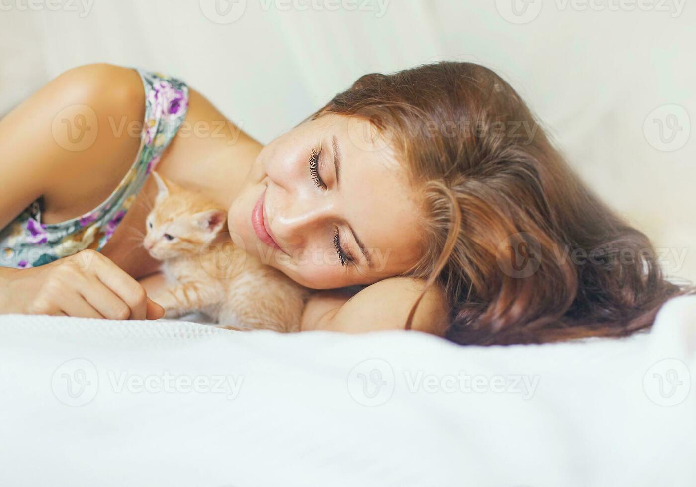 mulher relaxante em uma cama com uma muito fofa gatinho foto