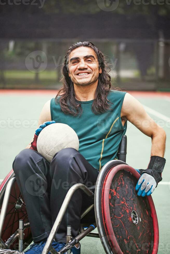 bonito determinado Desativado rúgbi jogador dentro uma cadeira de rodas praticando em uma estádio foto