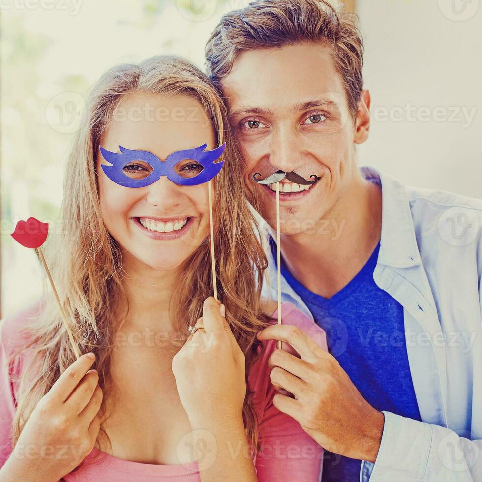 amador estilo retrato. casal posando com bastão lábios, mascarar, bigode acessórios. foto