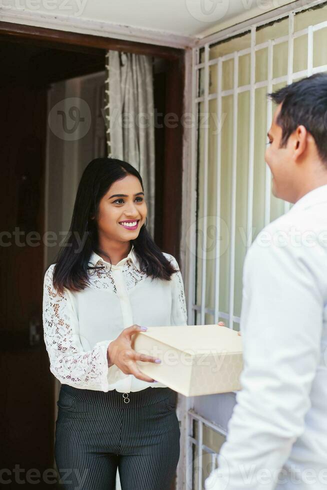 jovem indiano mulher recebendo Entrega pacote foto