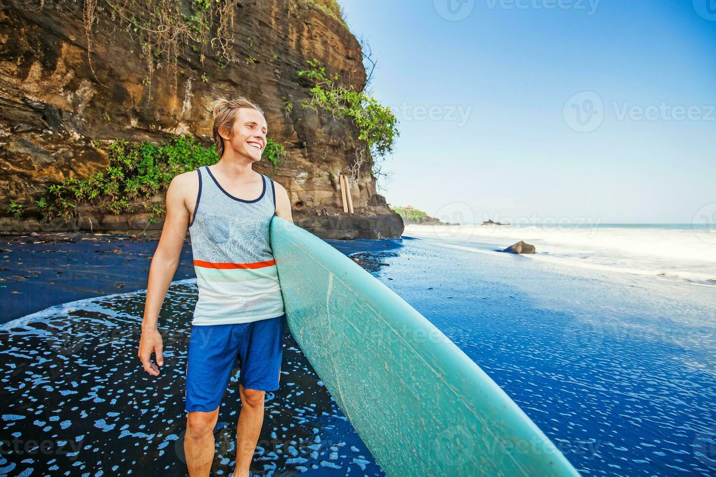 homem com prancha de surfe às a mar de praia foto