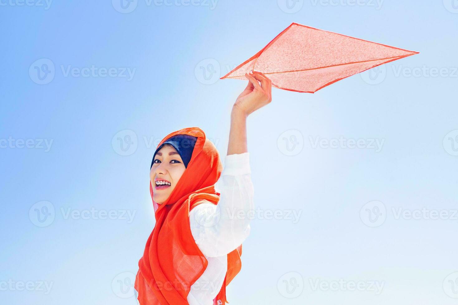 indonésio muçulmano mulher jogando com uma pipa em independência dia foto