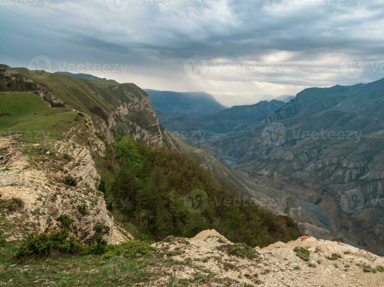 colorida chuvoso panorama com penhasco e grande rochoso montanhas e épico profundo desfiladeiro. Alto pedra picos do daguestão montanhas. foto