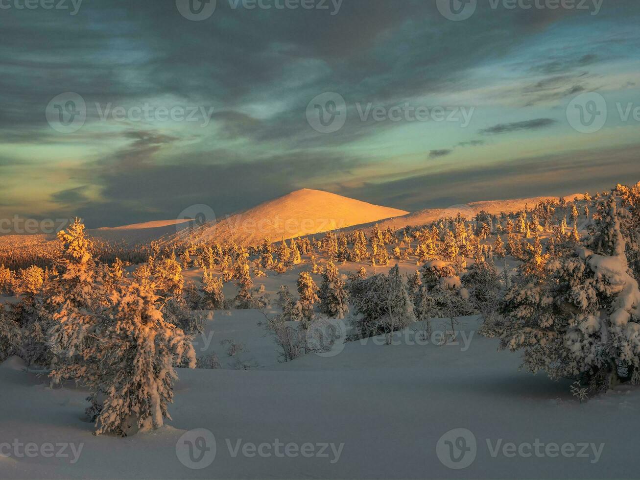 cobre colina. lindo ensolarado polar montanha com Sombrio tarde céu. pôr do sol dentro a inverno montanhas do khibiny, cola Península, Rússia. foto