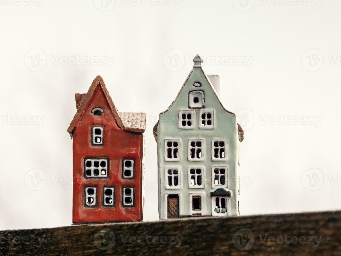 dois brinquedo casas em uma branco fundo. real Estado, construção, aluguel habitação conceito foto