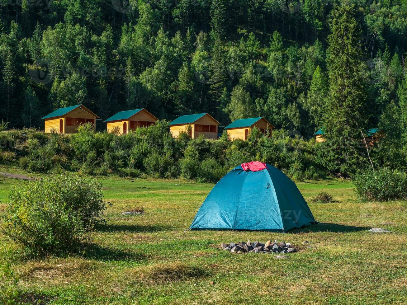 coletivo acampamento dentro a ecológico verde lugar. turista complexo, de madeira convidado casas contra a fundo do coberto de abeto Alto montanhas. foto