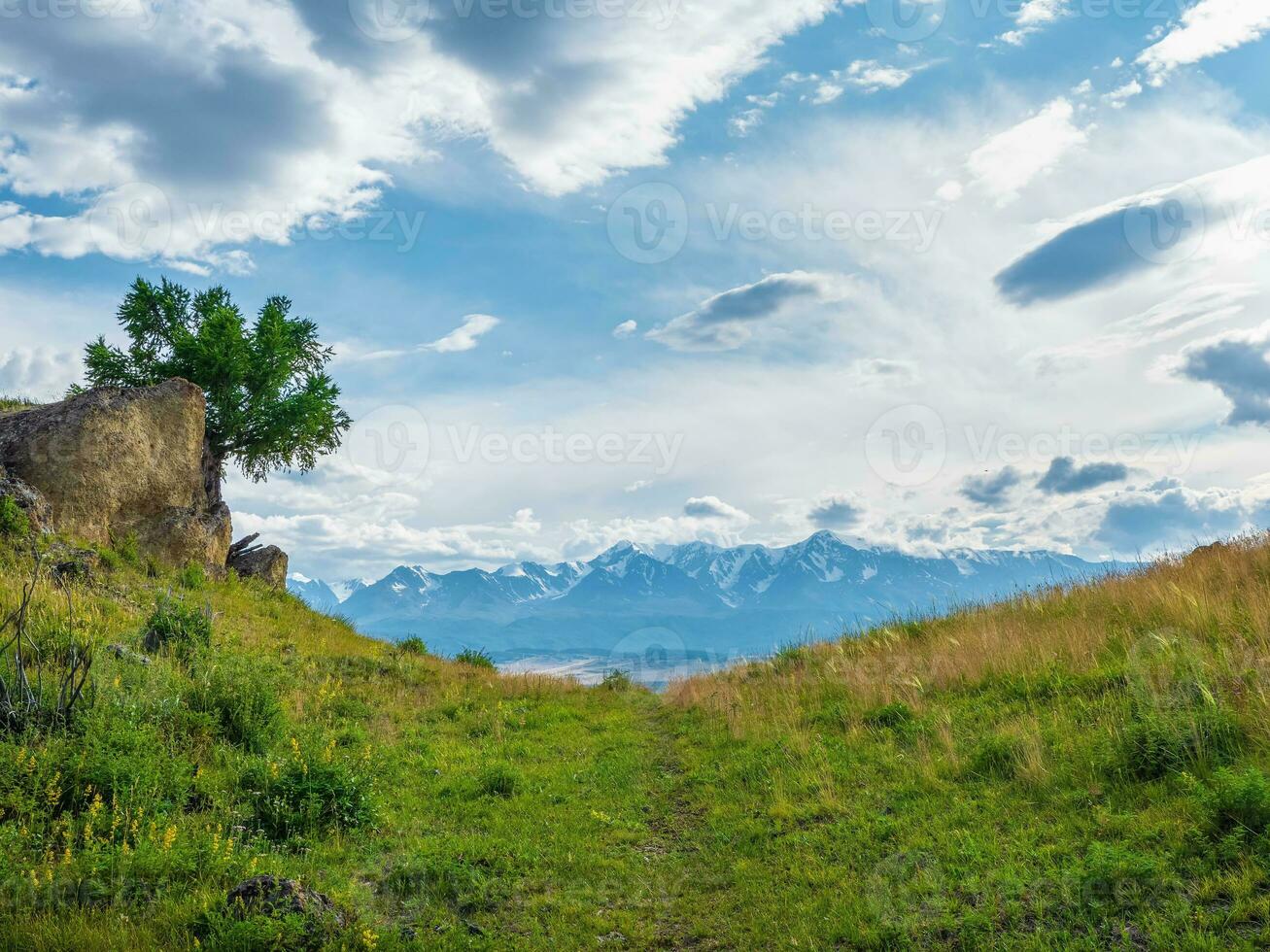 limitar caminho em a verão montanha declive. trilha através vale dentro terras altas dentro ensolarado dia. caminhada caminho. espetacular Visão do distante gigante montanhas. foto