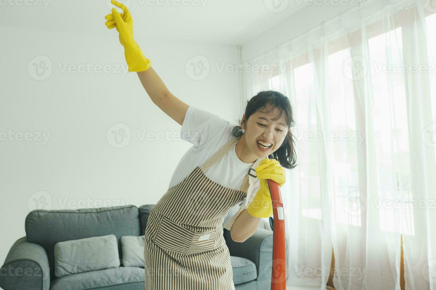 jovem mulher tendo Diversão enquanto limpeza lar. foto