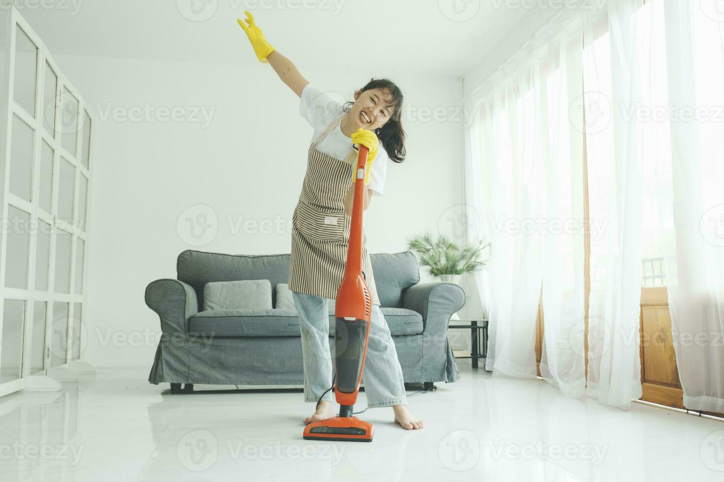 jovem mulher tendo Diversão enquanto limpeza lar. foto