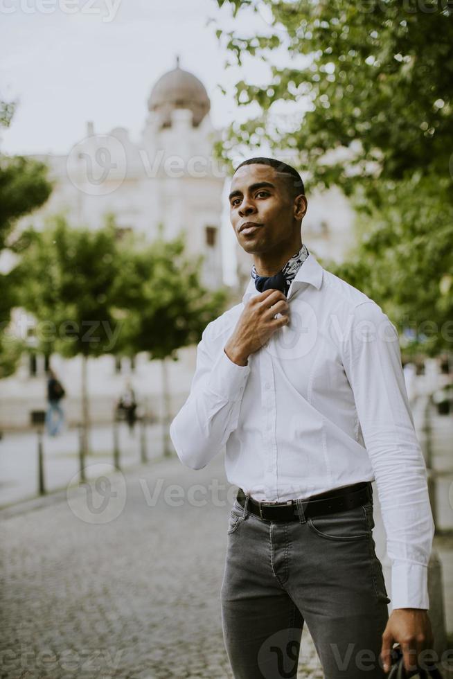 jovem empresário afro-americano esperando um táxi em uma rua foto