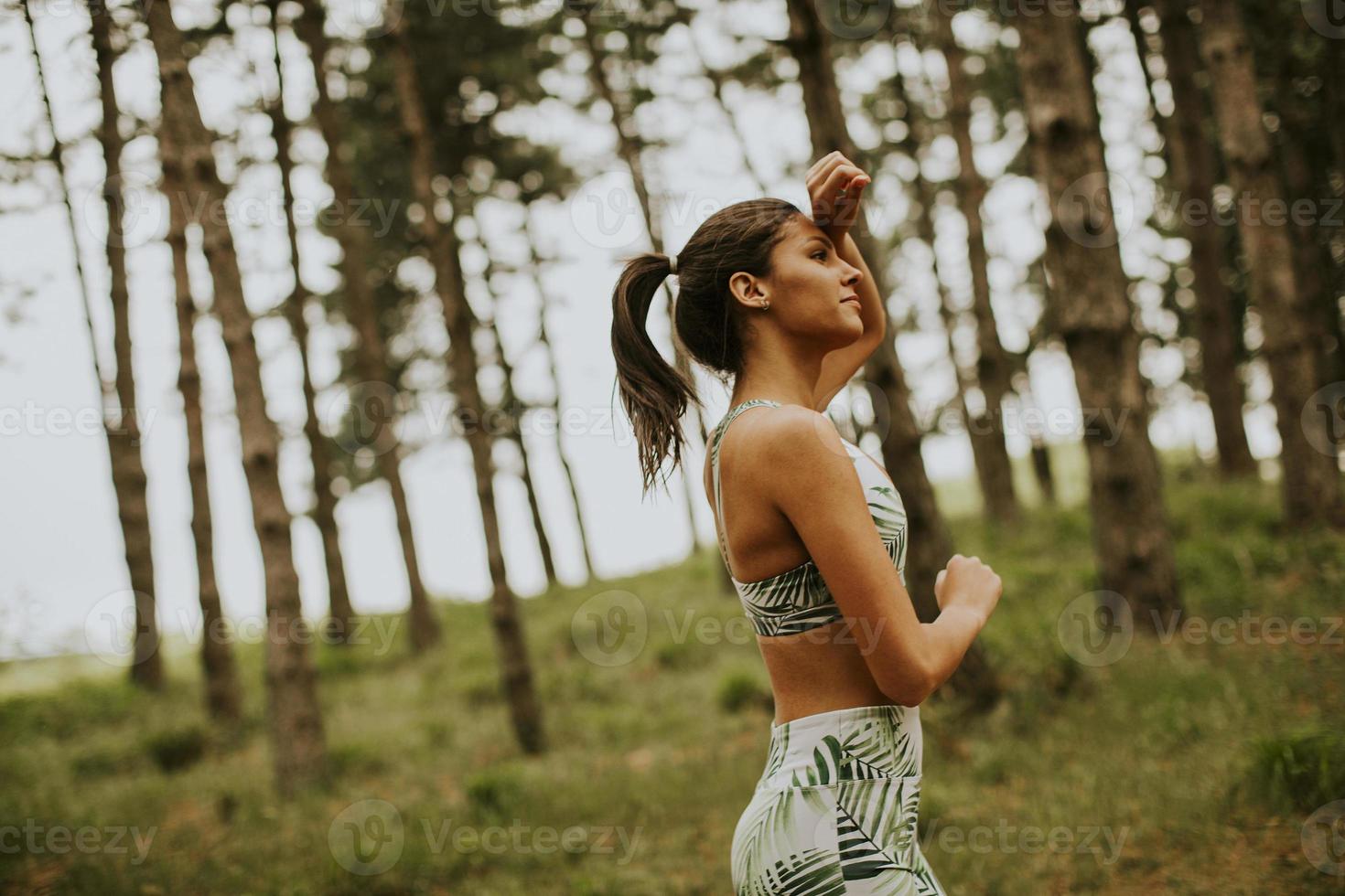 mulher jovem fitness correndo na trilha da floresta foto