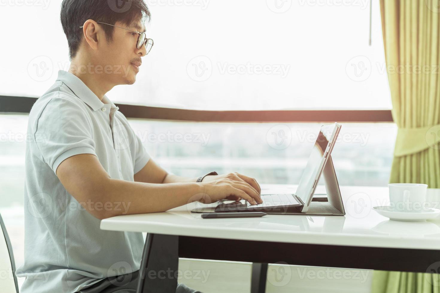 empresário sério focado ou freelancer de óculos e roupas casuais trabalhando no laptop foto